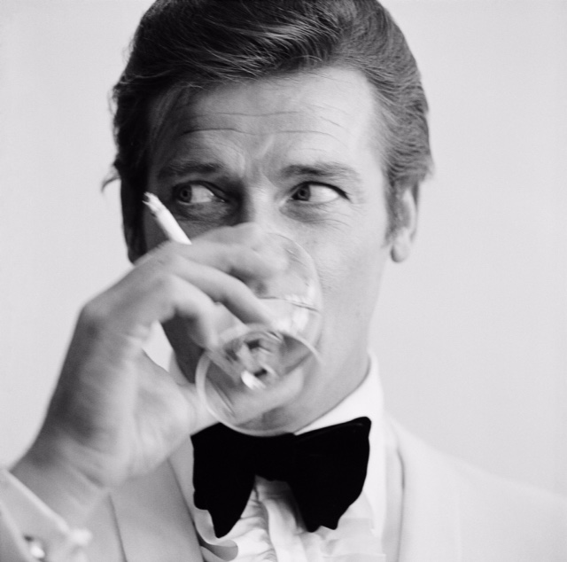 17th July 1968: English film star Roger Moore, well known for his roles as James Bond and the Saint, downs a martini. (Photo by Peter Ruck/BIPs/Getty Images)